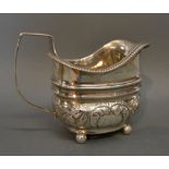 A George III Silver Sauce Jug of Embossed Form, with shaped handle,