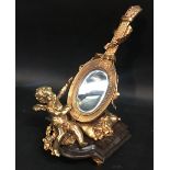 A French Ormolu Table Mirror in the form of a Musical Instrument with Putti Cresting upon a Cushion,