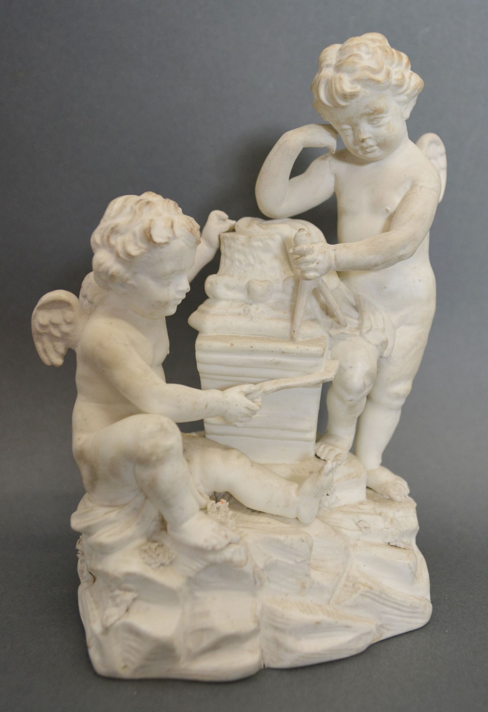 A Derby Bisque Group in the form of Putti Measuring a Column, impressed mark to base and number 39,