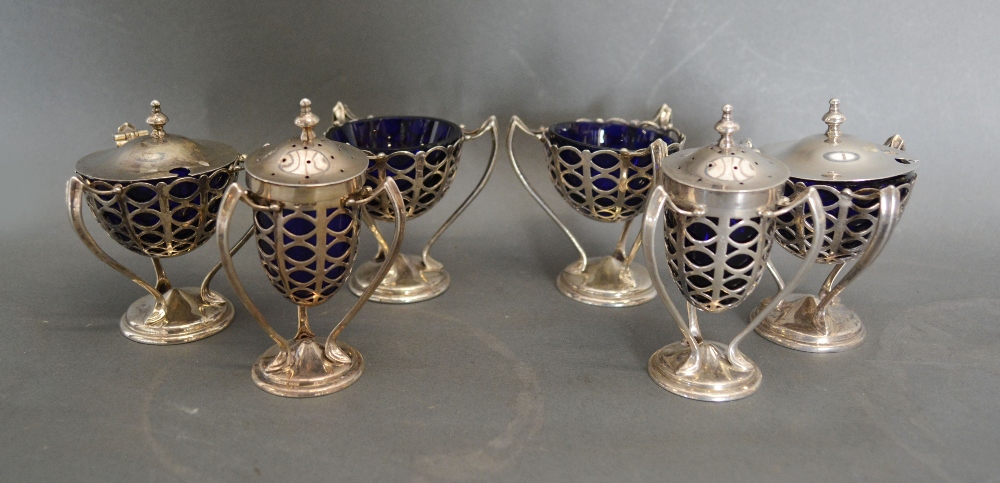 An Edwardian Silver Six Piece Condiment Set of Pierced Form with Blue Glass Liners and Tri-Form