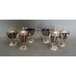 An Edwardian Silver Six Piece Condiment Set of Pierced Form with Blue Glass Liners and Tri-Form