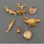 A Group of Seven 9ct. Gold Charms to include a lamp, a figure, a fish and others, 7.