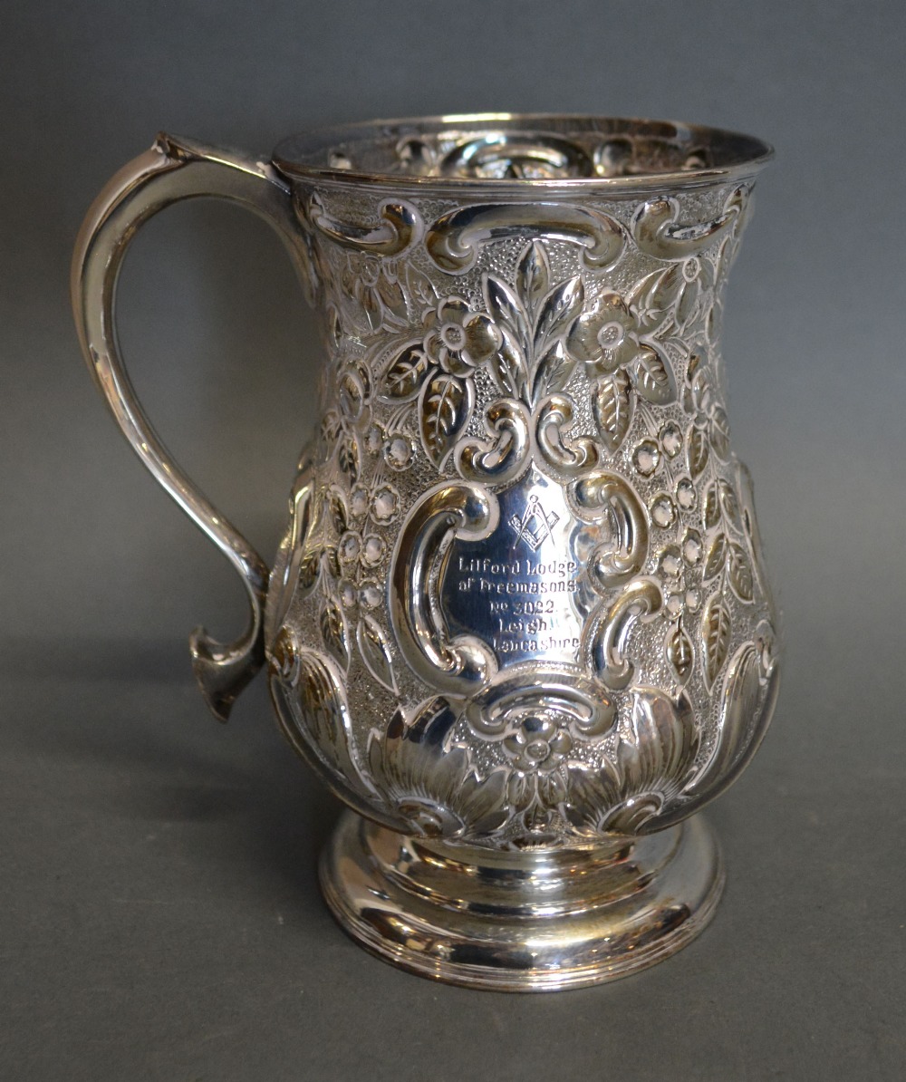 A Victorian Silver Mug with Embossed Foliate and Scroll Decoration,
