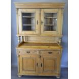 A Victorian Pine Dresser, the moulded cornice above two glazed doors enclosing shelves,