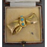 A Gold Brooch of Bow Form set with three Turquoise within fitted case