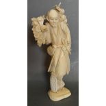 A 19th Century Japanese Carved Ivory Okimono in the form of a Tradesman carrying Fruit and Flowers,