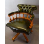 A Reproduction Green Leather Revolving Office Armchair with a button upholstered back raised upon