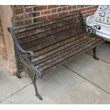 A Painted Wrought Iron and Slatted Garden Bench with pierced end supports,