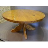 A Large Circular Pine Dining Table, the heavy plank top above shaped supports,