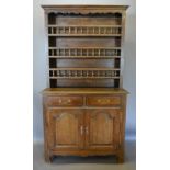 A French Oak Dresser, the boarded shelf back above two drawers and two arched cupboard doors,