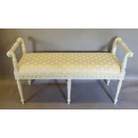 A Painted Window Seat with Scroll Arms above a padded seat raised upon turned tapering reeded legs,