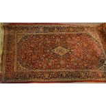 A North West Persian Woollen Rug with an all over design upon a red,