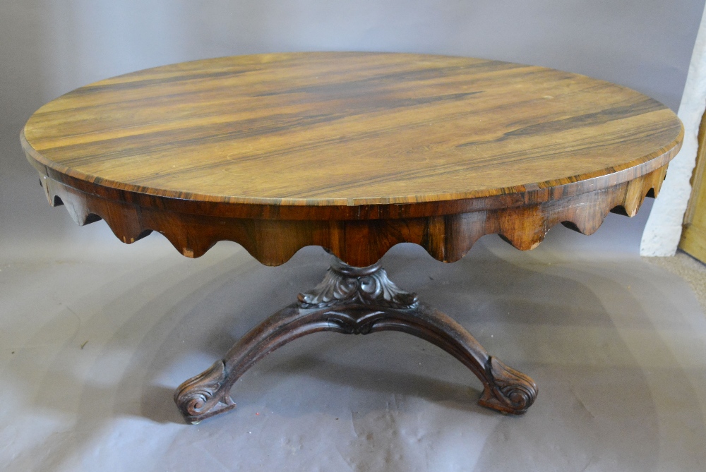 A Victorian Rosewood Centre Table with a shaped frieze raised upon a carved centre column with