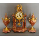 A French Rouge Marble and Gilt Metal Mounted Three Piece Clock Garniture,