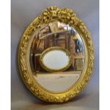 An Oval Gilded Wall Mirror with Ribbon Bow Cresting,