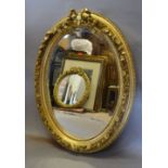 An Oval Gilded Wall Mirror with Ribbon Bow Cresting,