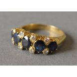 An 18ct Yellow Gold Sapphire and Diamond Band Ring set with five sapphires flanked by eight