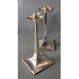 A Pair of Arts and Crafts Candlesticks of Stylised Form with square bases retailed by James Dixon &