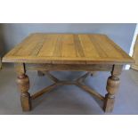 An Early 20th Century Oak Draw Leaf Dining Table, with four baluster legs and cross over stretchers,