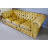 A Beige Leather Button Upholstered Chesterfield Sofa with Scroll Arms,