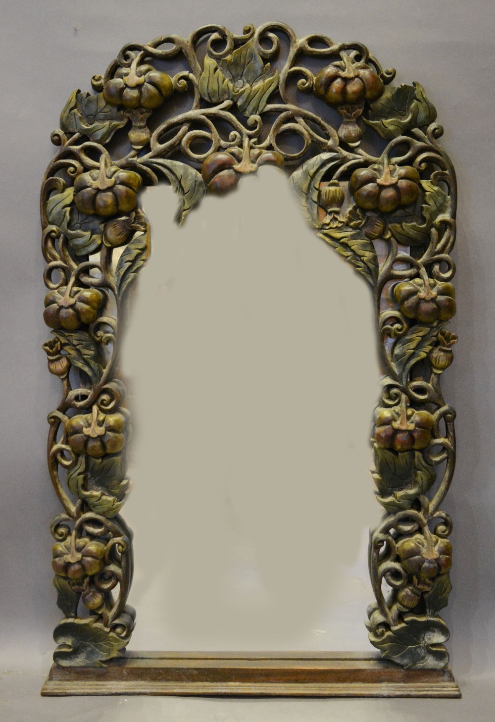 An Oak Wall Mirror, the pierced border mounted with fruit,