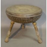 An Engraved Decorated Brass Ankara Foot Warming Stool with Circular Top above three turned supports,