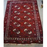 A Bokhara Woollen Rug, with two rows of five guls within multiple borders upon a red ground,
