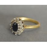 An 18ct Gold Diamond and Sapphire Cluster Ring with a central sapphire surrounded by diamonds