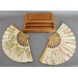 A Far East Prisoner of War Pair of Fans with simple fans hand painted and decorated with silver