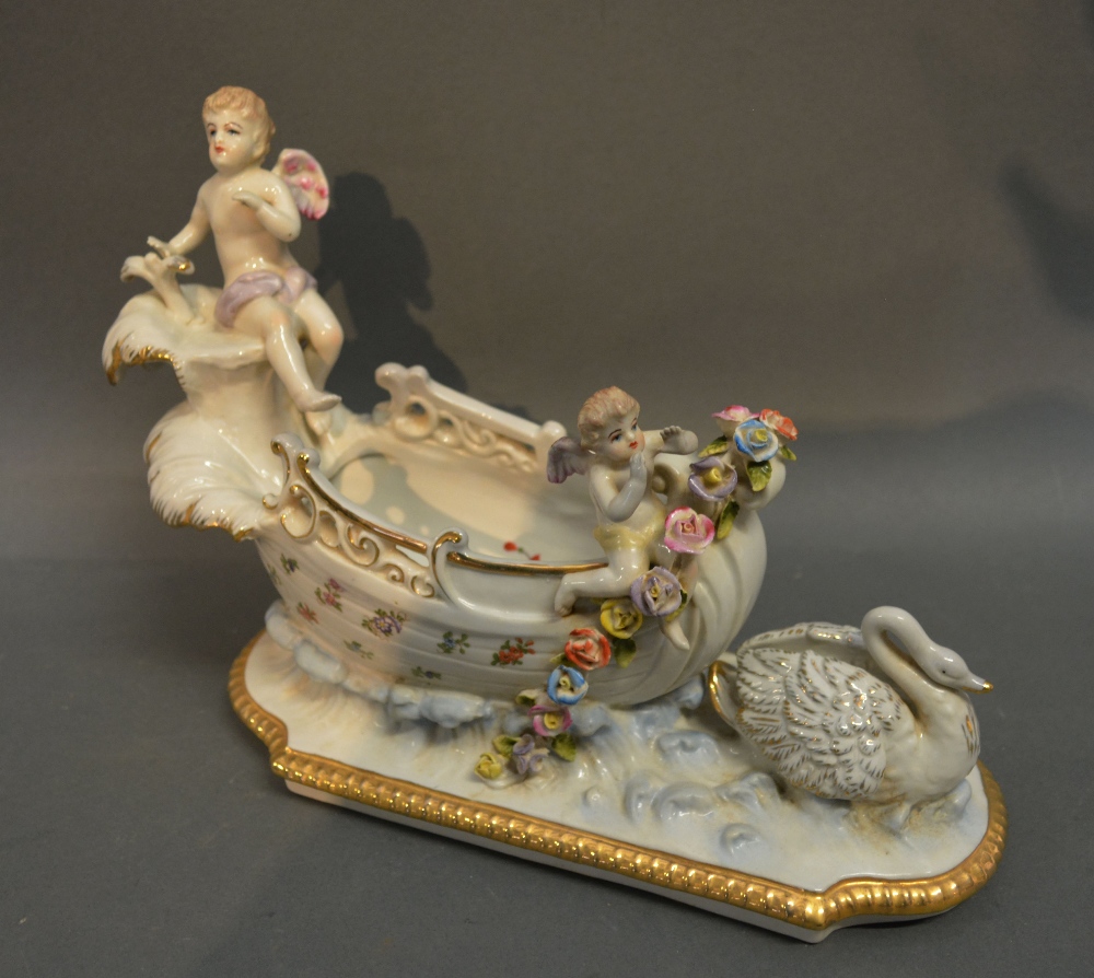 A German Porcelain Vase in the form of a Chariot mounted with Putti and Swan,