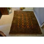A Bokhara Woollen Carpet with three rows of guls upon a terracotta ground within an all over design