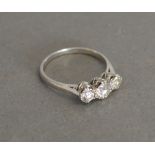 A Platinum Three Stone Diamond Ring with a central diamond flanked by smaller diamonds,