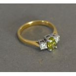 An 18ct. Yellow Gold Three Stone Ring, the central green stone heat treated, approximately 0.65 ct.