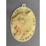 A 19th Century Japanese Carved Ivory Pendant in the form of a Tiger's Head,