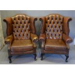 A Pair of Brown Leather Button Upholstered and Brass Studded Wingback Armchairs