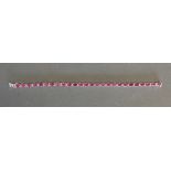 An 18ct White Gold Ruby and Diamond Line Bracelet, rubies 13.17 ct, diamonds 0.