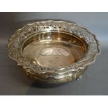 An Edwardian Silver Large Bowl with a pierced shaped rim raised upon three scroll feet, London 1903,