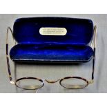 Antique pair of spectacles in blue box with opticians marking on cover.