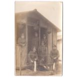 Army Service Corps WWI-RP postcard, group of seven by a very basic hut, clear insignia