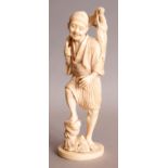 A SIGNED JAPANESE MEIJI PERIOD IVORY OKIMONO OF A FISHERMAN, standing next to a rocky plinth and