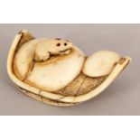 A 19TH CENTURY JAPANESE EDO/MEIJI PERIOD IVORY NETSUKE OF A RAT ON A CURVED REED MAT, 2.1in wide.