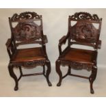 A PAIR OF EARLY 20TH CENTURY CHINESE CARVED HARDWOOD ARMCHAIRS, each back carved in high relief with