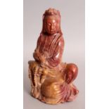 A 19TH/20TH CENTURY CHINESE SOAPSTONE FIGURE OF GUANYIN, reclining against a rockwork plinth and