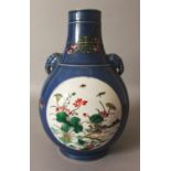 A CHINESE BLUE GROUND FAMILLE ROSE PORCELAIN HU VASE, decorated with two circular panels of birds