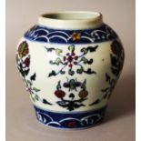 A CHINESE MING STYLE DOUCAI PORCELAIN JAR, decorated with formal foliage between wave borders, the