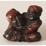 A JAPANESE MEIJI PERIOD CARVED WOOD NETSUKE OF A MASK MAKER, 1.3in wide & 1.2in high.