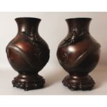 A LARGE MIRROR PAIR OF JAPANESE MEIJI PERIOD BRONZE DRAGON VASES, together with fitted wood