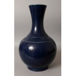 A GOOD CHINESE MONOCHROME BLUE GLAZED PORCELAIN BOTTLE VASE, the deep glaze with an orange peel