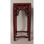 A CHINESE TALL SQUARE SECTION HARDWOOD STAND, the frieze carved with ribboned 'cash', 6in square &