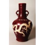 A CHINESE MING STYLE RED GROUND PORCELAIN VASE, decorated in raised unglazed relief with an